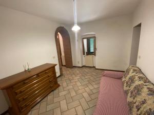 a living room with a couch and a wooden dresser at Lo Sdrucciolo in Laterina