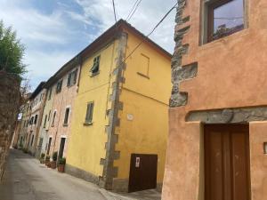 um edifício amarelo no lado de uma rua em Lo Sdrucciolo em Laterina