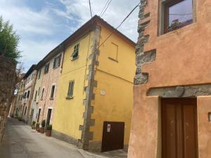 ein gelbes Gebäude an der Straßenseite in der Unterkunft Lo Sdrucciolo in Laterina