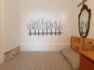 a room with a mirror and some branches on the wall at Monolocale rustico di Ariola in Cansano