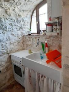 a kitchen with a sink and a microwave at Monolocale rustico di Ariola in Cansano