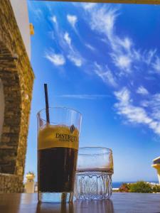 een drankje in een glas zittend op een tafel bij Tinos View Apartments in Tinos Town