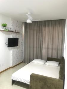 a bedroom with a bed and a flat screen tv at ESPETACULAR!! Apto na PRAIA DE ITAPARICA - Com Wi-Fi 360mbps, Ar Condicionado, Estacionamento, Globoplay e Cozinha Completa in Vila Velha