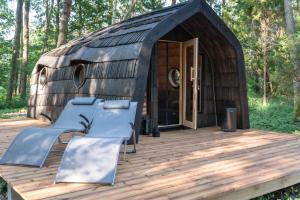 une grande terrasse en bois avec une cabane de chaume dans l'établissement Hundi kämping, à Hiiessaare