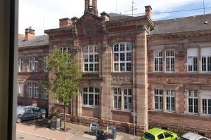 a large brick building with cars parked in front of it at - 2 - Très Bel Appart Charmant et Moderne 5Pers T3 73m2 in Sélestat