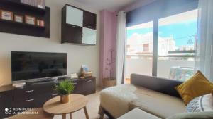 A television and/or entertainment centre at LA PITA- Terraza con vistas al mar & parking, a 1 min de la playa