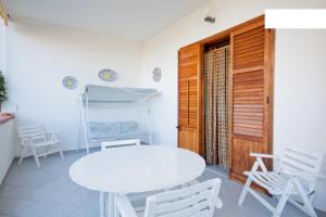 einen weißen Tisch und Stühle in einem Zimmer in der Unterkunft Villetta a 10 minuti, a piedi, dalla spiaggia in San Vito lo Capo
