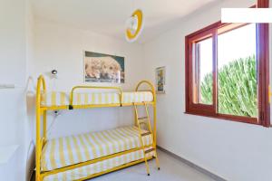 een geel stapelbed in een kamer met een raam bij Villetta a 10 minuti, a piedi, dalla spiaggia in San Vito lo Capo