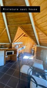 una cocina con mesa y sillas en una cabaña en Miniature oast house, en Ash