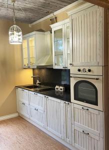 cocina con armarios blancos y microondas en Rüütli 1 - sea view apartement in Haapsalu Old Town en Haapsalu
