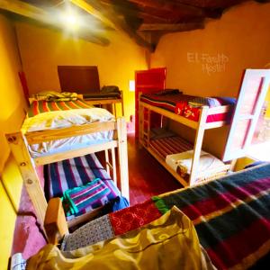 a bedroom with a bed, desk and a laptop at El Farolito Hostel in Tilcara