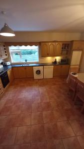 uma grande cozinha com piso em azulejo e uma mesa em Breathneach House em Limerick