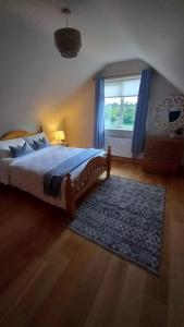 a bedroom with a bed with a blue rug and a window at Breathneach House in Limerick