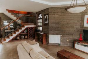 a living room with a couch and a staircase at Casa de Pedra na Serra Gaucha in Carlos Barbosa