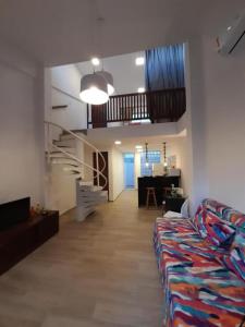 a living room with a couch and a staircase at Praias Bellas Aconchegante Duplex in Pirangi do Norte