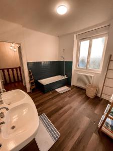 a bathroom with a sink and a bath tub at LA BUTTE - Maison de vacances Avranches avec vue sur le Mont Saint Michel in Le Val-Saint-Père