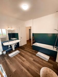 a bathroom with a bath tub and a sink and a bath tub at LA BUTTE - Maison de vacances Avranches avec vue sur le Mont Saint Michel in Le Val-Saint-Père +34 photos