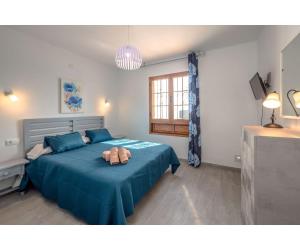 Un dormitorio con una cama con una manta azul. en Puerto Chico Y, en Playa Blanca