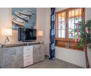 een woonkamer met een tv en een raam bij Puerto Chico Y in Playa Blanca