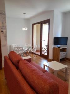 ハライス・デ・ラ・ベラにあるApartamentos Doctor Flemingの赤いソファとテーブルのあるリビングルーム