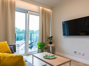 VacationClub – Sosnowa 4 Apartament 36 في ميلنو: غرفة معيشة مع أريكة وطاولة