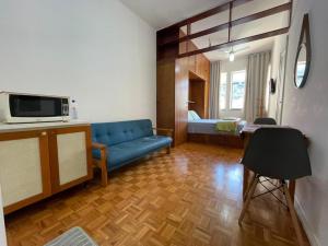 ein Wohnzimmer mit einem blauen Sofa in einem Zimmer in der Unterkunft Studio Buckingham Palace in Teresópolis