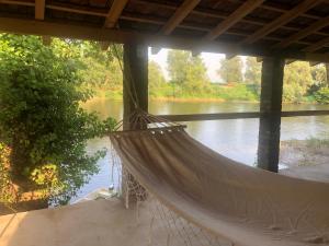 a hammock hanging under a bridge over a river at Apartmani Morava 54 in Kočino Selo