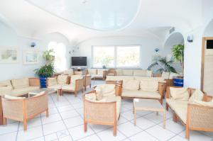 a waiting room with chairs and tables and a tv at Hotel Felix Terme in Ischia