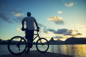 a man standing on a dock with a bike at Copacabana Way - 4 Hóspedes, Praia e Privativo in Rio de Janeiro
