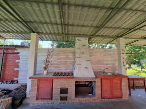 an outdoor kitchen with a stove in a pavilion at Lux villa on the river Dnipro in Kirovskoye