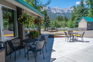 a patio with tables and chairs in front of a building at Pocaterra Inn & Waterslide in Canmore