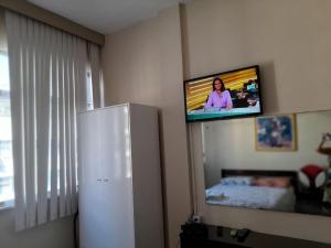 einen TV an der Wand in einem Zimmer mit einem Kühlschrank in der Unterkunft santa clara 1003 in Rio de Janeiro