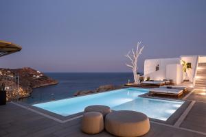a pool with chairs and a view of the ocean at Amyth of Mykonos Super Paradise in Super Paradise Beach