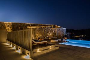 a rooftop patio with a pool at night at Amyth of Mykonos Super Paradise in Super Paradise Beach