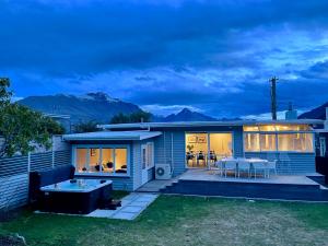 a house with a hot tub in the yard at Villa Queenstown in Queenstown