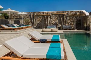 a pool with lounge chairs and a swimming pool at Amyth of Mykonos Super Paradise in Super Paradise Beach
