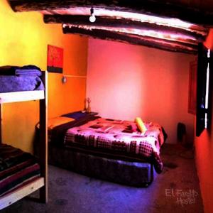 1 dormitorio con 2 literas y pared roja en El Farolito Hostel en Tilcara