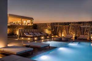 a swimming pool with lounge chairs and a hotel at Amyth of Mykonos Super Paradise in Super Paradise Beach