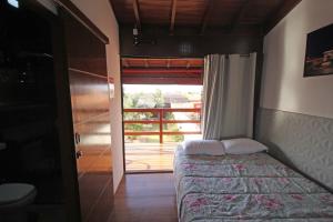 a bedroom with a bed and a door to a balcony at Recanto Reino Encantado in Olímpia