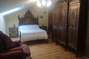 1 dormitorio con 1 cama grande y muebles de madera en As Campanillas, en Cabana de Bergantiños