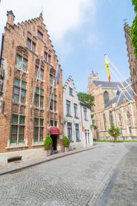 an empty street in front of a brick building at Hotel Het Gheestelic Hof in Bruges