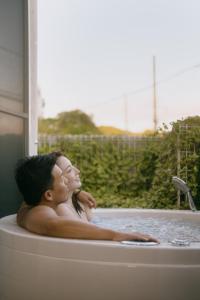 un hombre y una mujer sentados en una bañera en Casablanca Pool House, en Kamakura