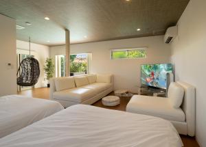 sala de estar con 2 camas y sofá en Casablanca Pool House, en Kamakura