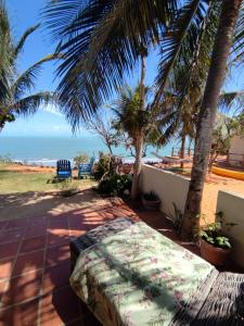 a bed on a patio with a view of the ocean at Pousada Vila Matury in Icapuí