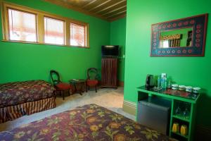 Grünes Zimmer mit 2 Betten und einem Spiegel in der Unterkunft Sea Breeze B & B in Napier