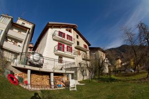 a building with red doors and balconies on it at Tesino Appartamenti 2 in Castello Tesino