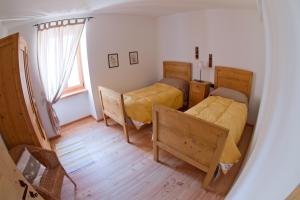 a small bedroom with two beds and a window at Tesino Appartamenti 2 in Castello Tesino