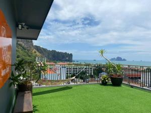 a balcony with green grass and a view of the ocean at Aonang Dugong-SHA Extra Plus in Ao Nang Beach