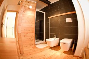 a bathroom with a toilet and a sink at Tesino Appartamenti 2 in Castello Tesino