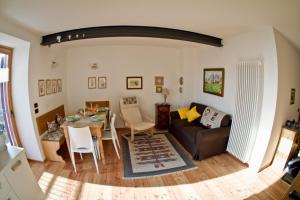 ein Wohnzimmer mit einem Tisch und einem Sofa in der Unterkunft Tesino Appartamenti 2 in Castello Tesino